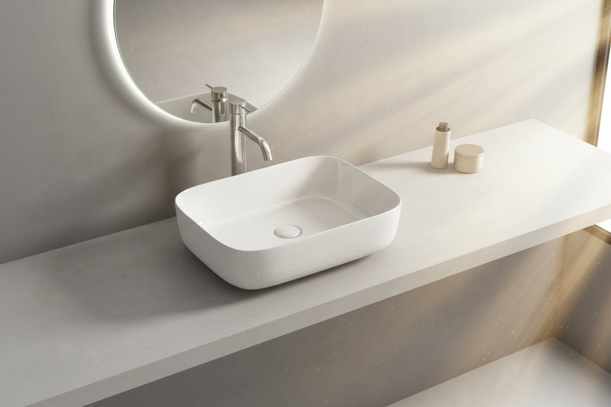 White rectangular sink on a gray countertop with a mirror above