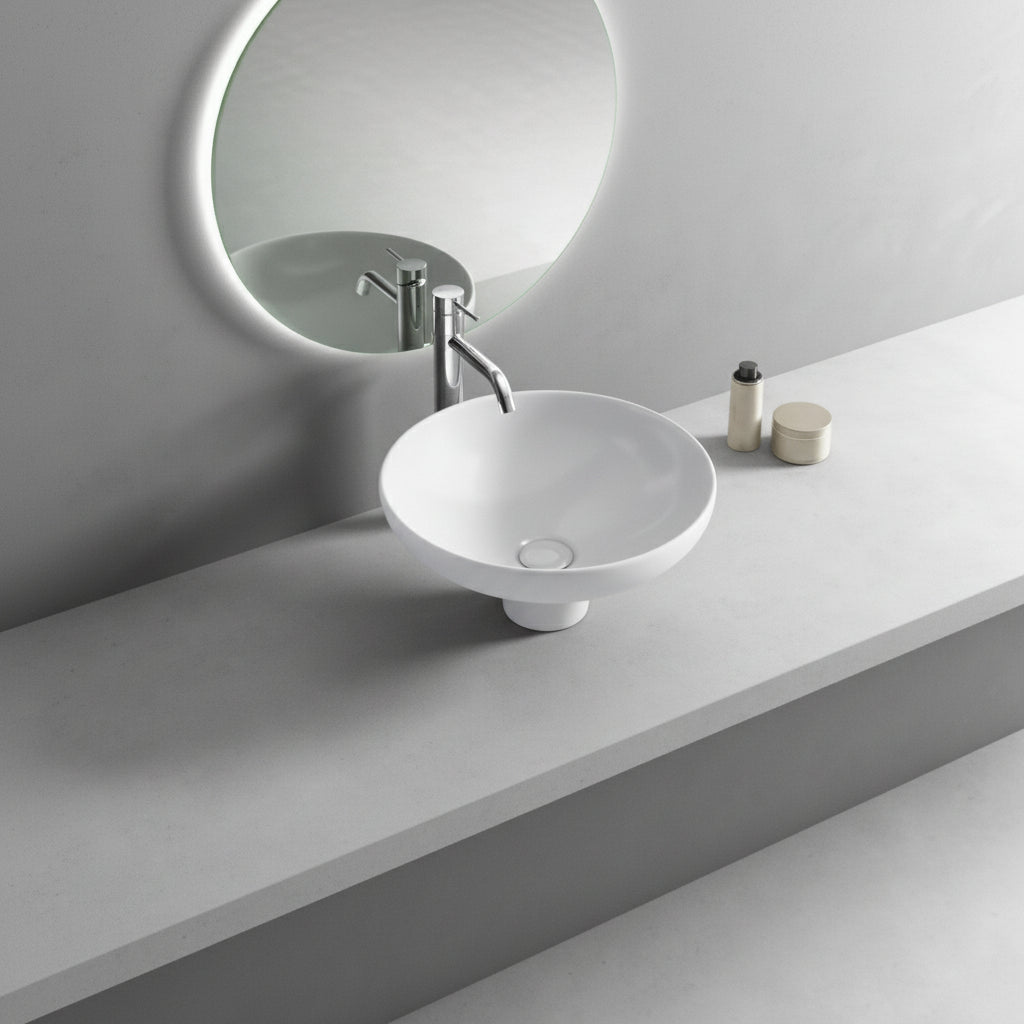 White sink with faucet on a gray countertop with a mirror above.