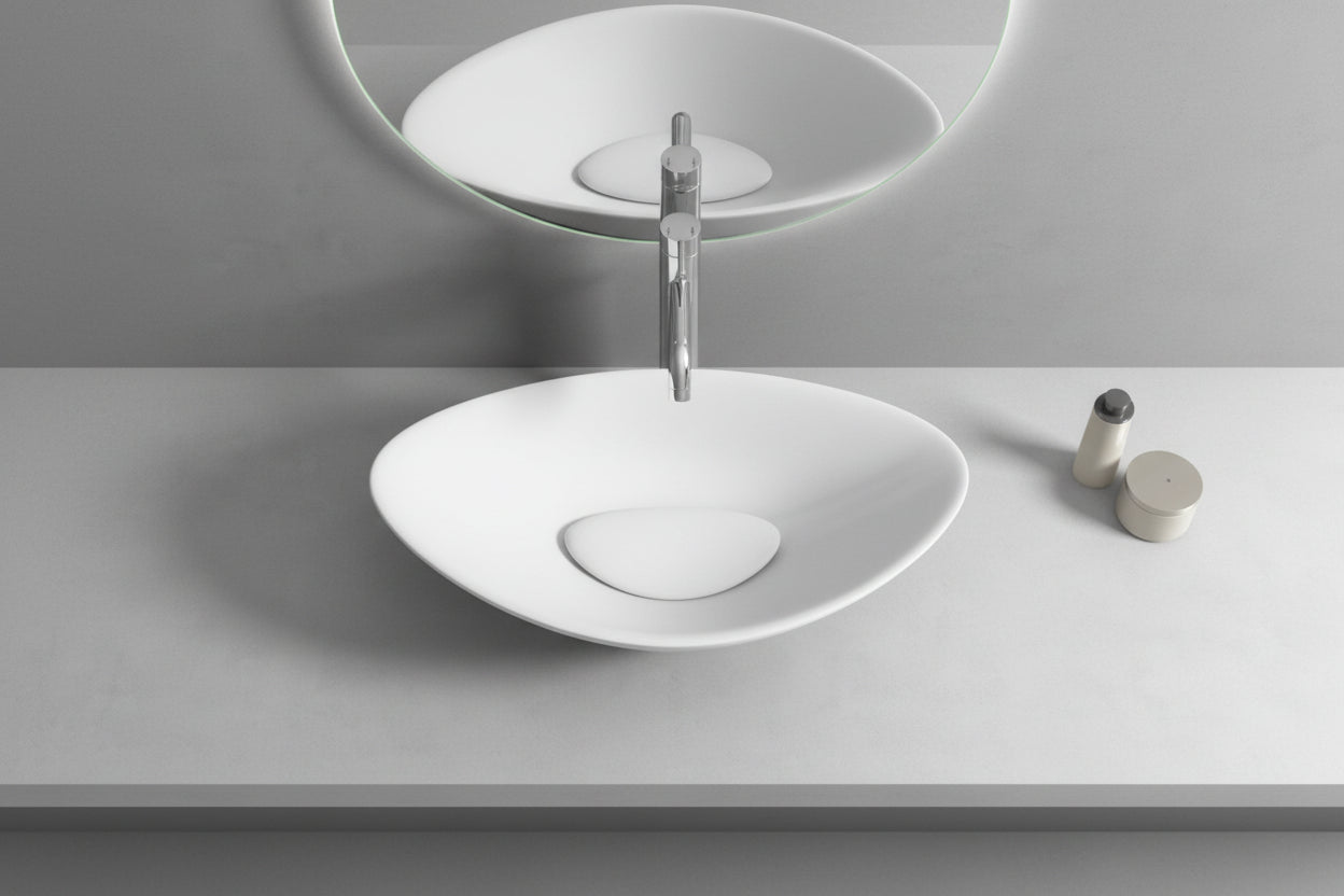 White oval sink on a gray countertop with a mirror above