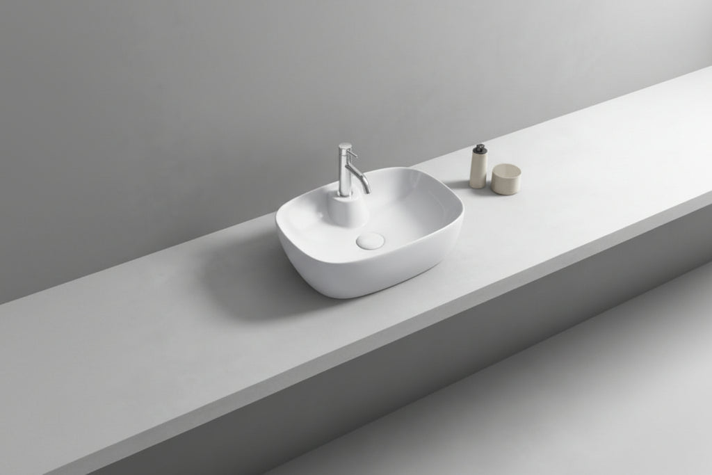 Bathroom vanity with a white sink and round mirror on a light gray wall.